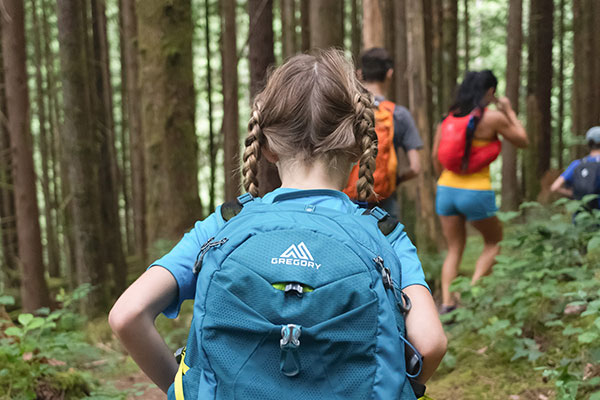 Photo of a family hiking through the forest by Greg Rosenke